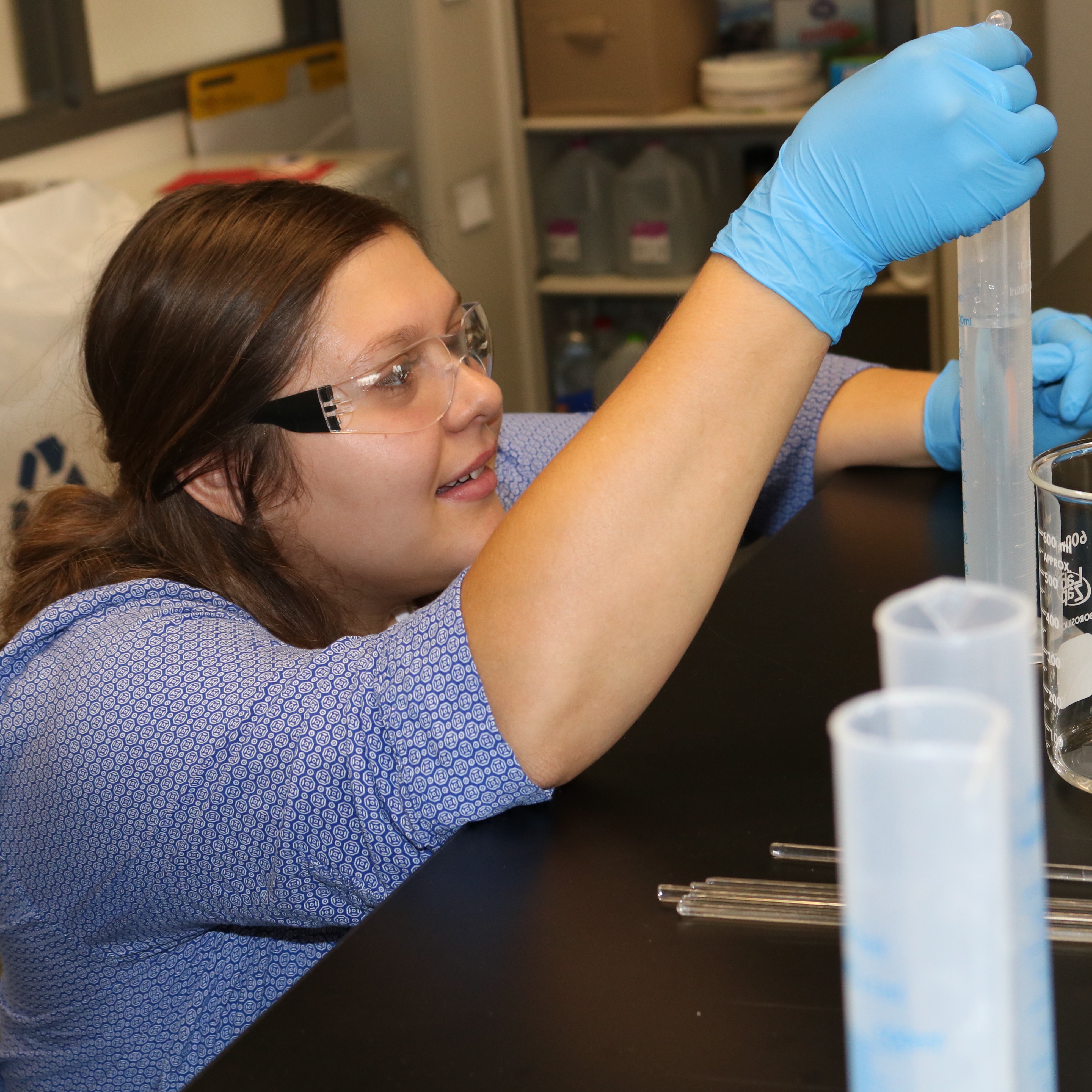 A student using a pipette and test tube. 